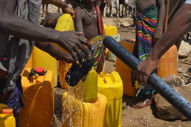 Een jerrycan wordt gevuld met schoon drinkwater