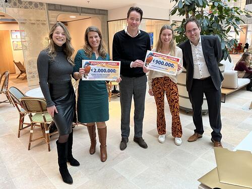 Amref-medewerkers worden verrast met een cheque van twee miljoen.