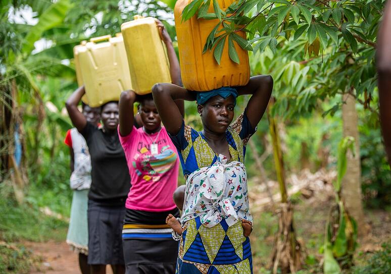 Vrouwen gaan na het water halen terug naar huis